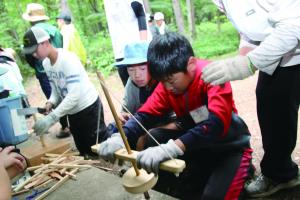 火起こしを体験する子ども