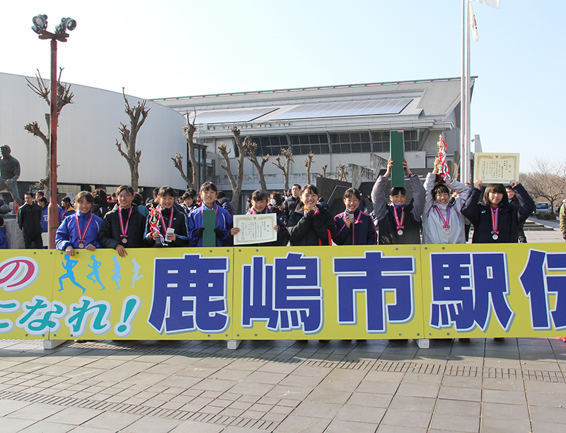 看板を前に記念撮影（中学生女子の部優勝・波崎一中女子駅伝チーム）