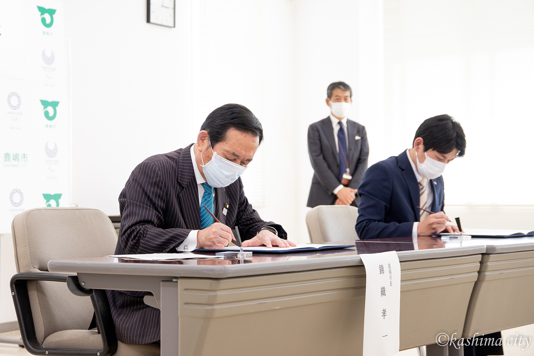 締結書にサインをする市長