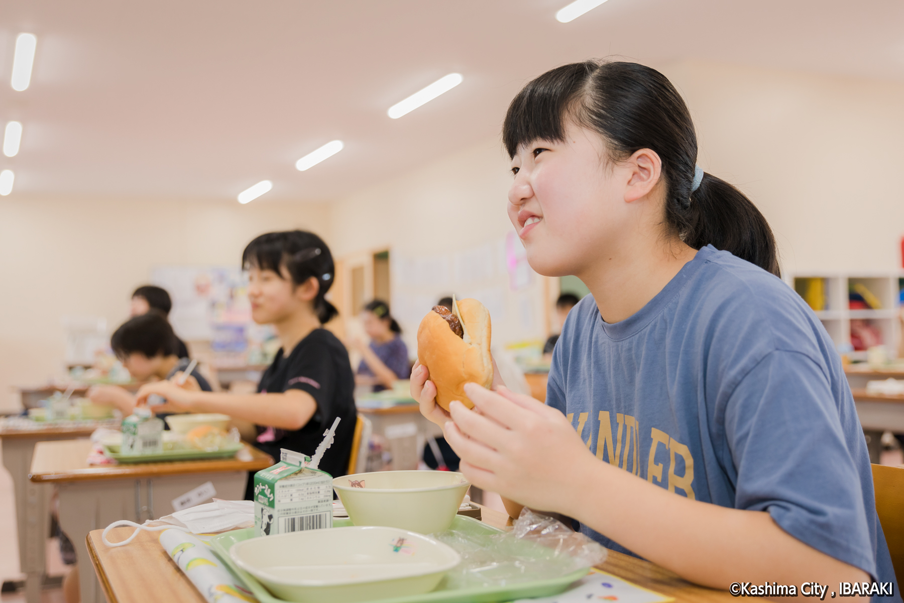 チーズバーガーを食べる児童