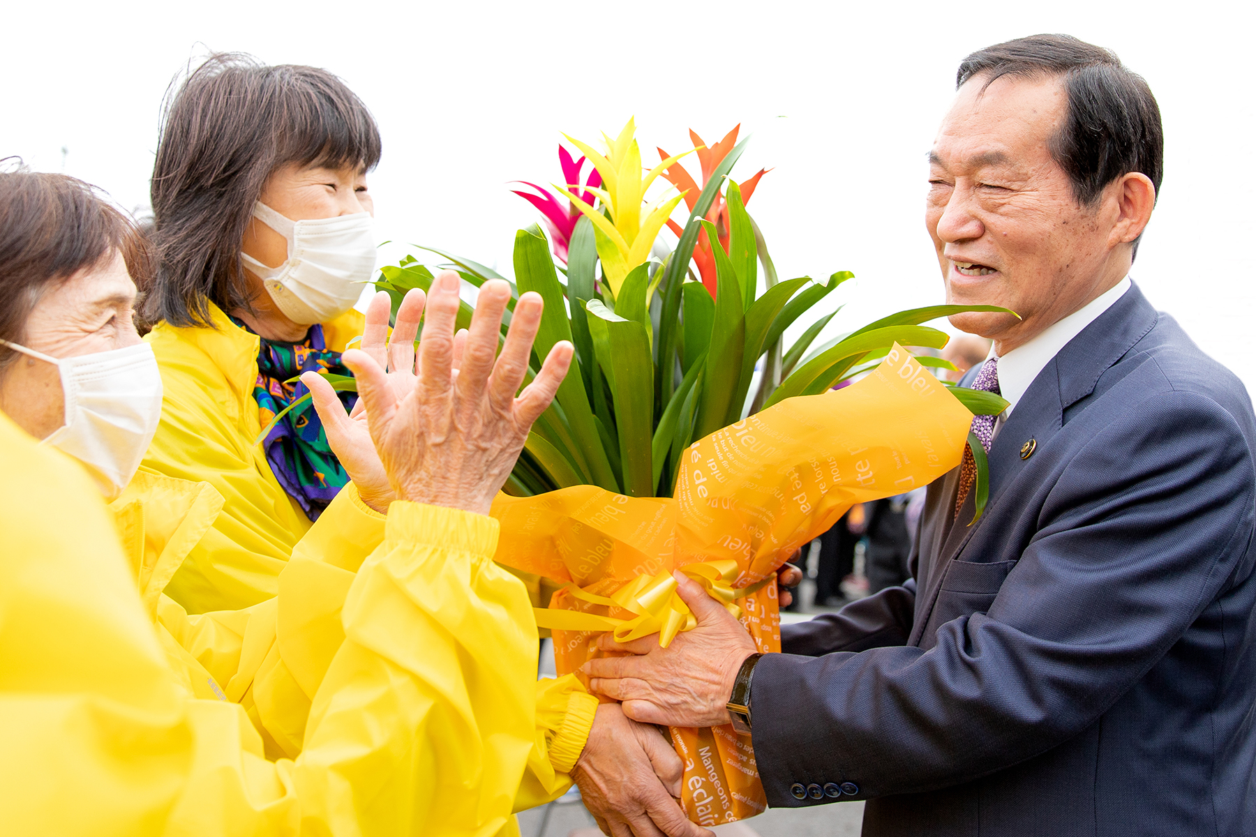 退任のあいさつ後、市民から花束を笑顔でもらう錦織孝一市長