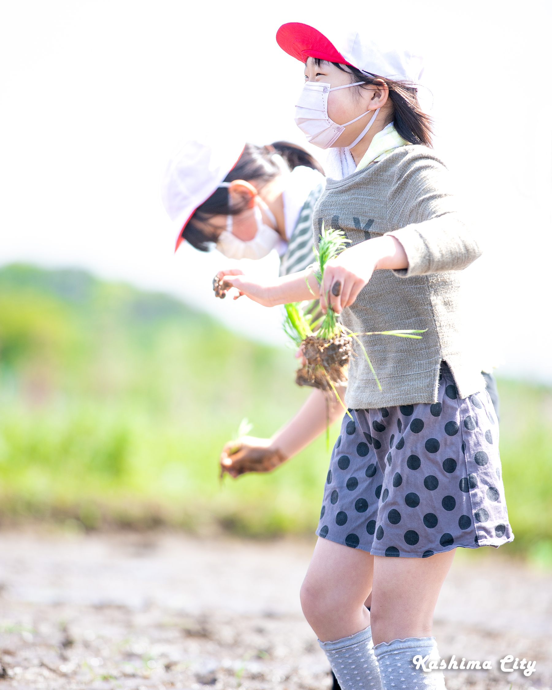 初めての田植えで笑顔になる女子生徒