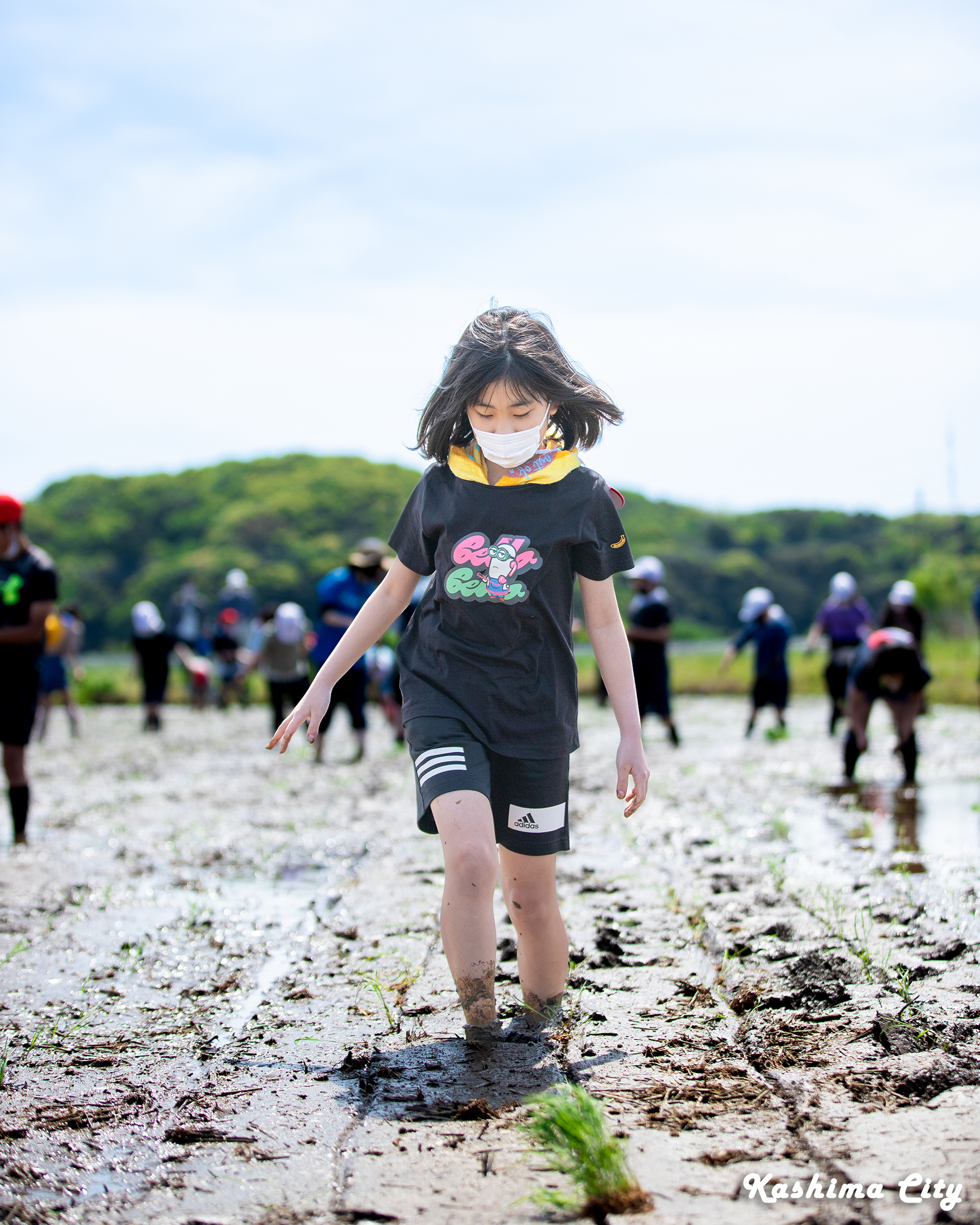 田んぼ内を歩いて進む女子生徒