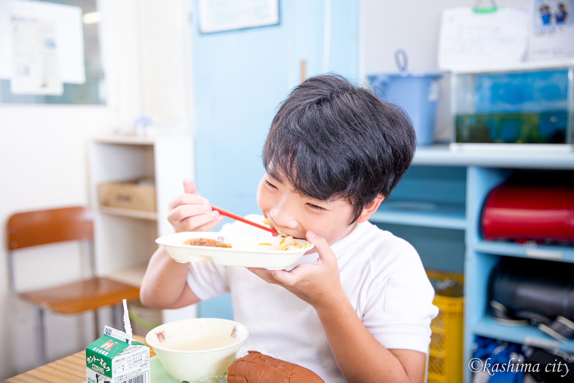 鹿島灘産しらす入りの給食を元気よく頬張る男子児童