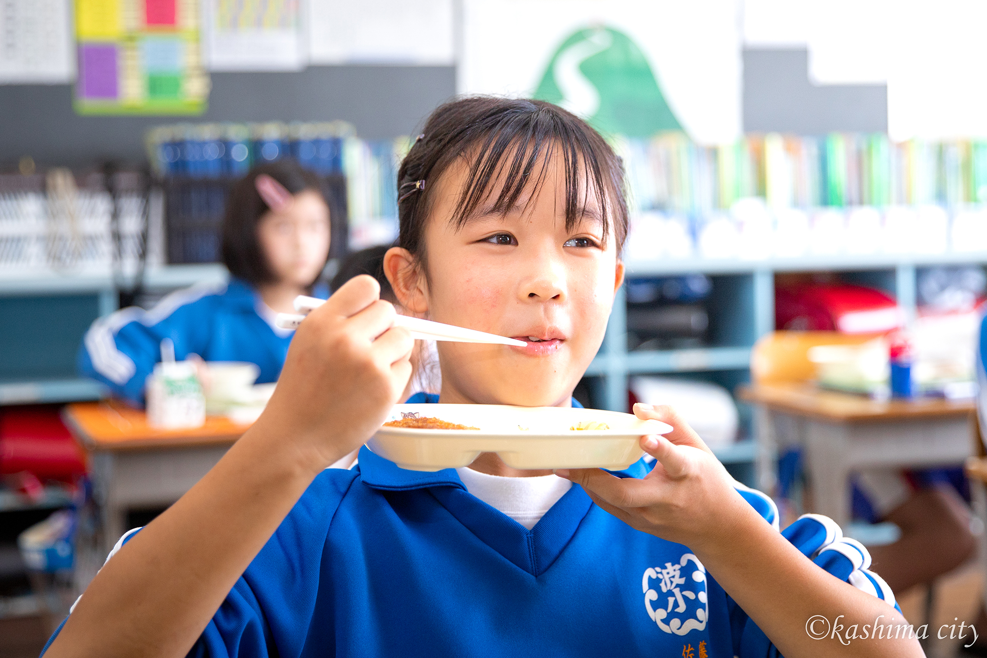 鹿島灘産しらす入りの給食を元気よく頬張る女子児童