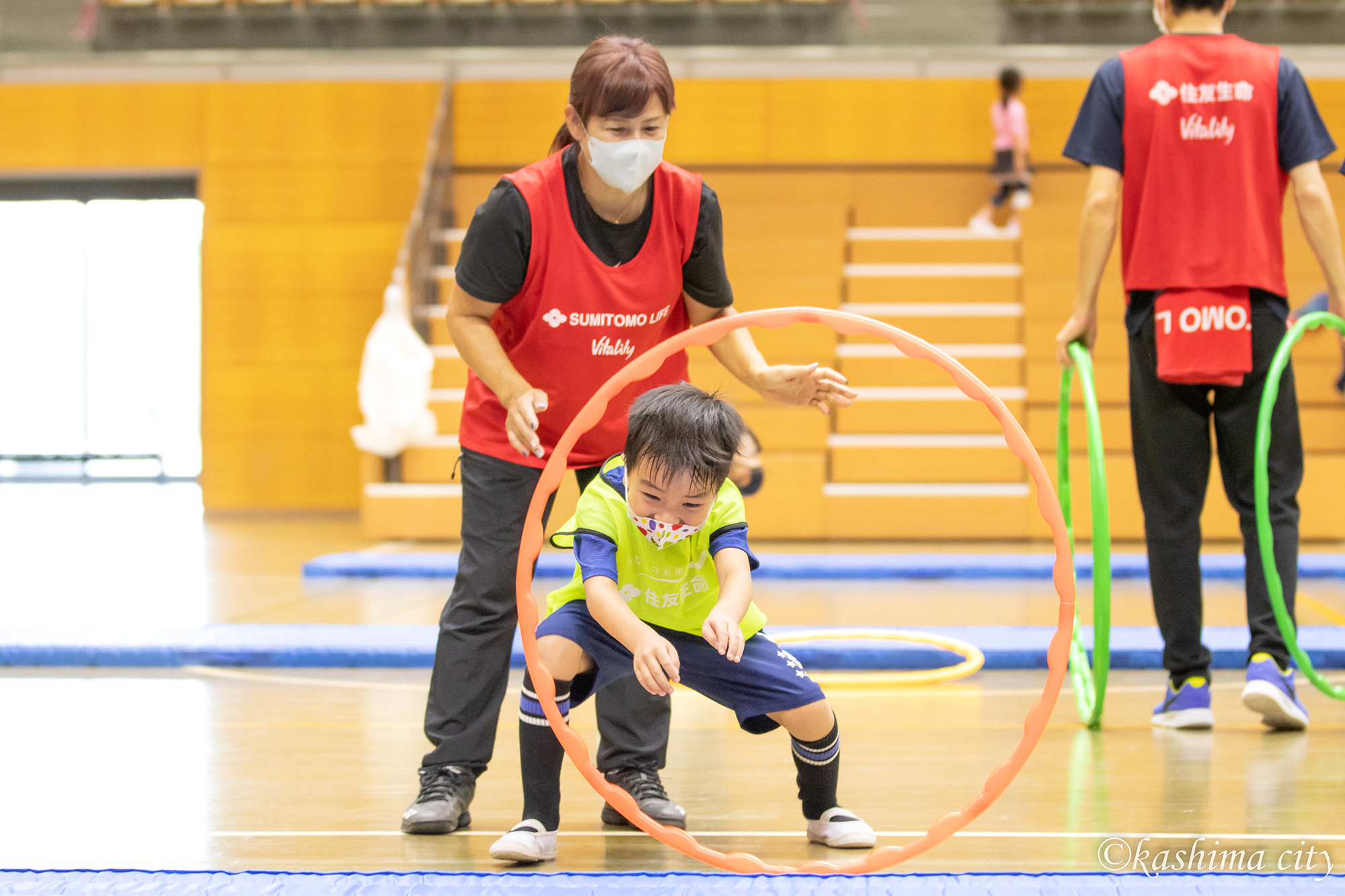 フラフープを潜り抜けようとする男の子