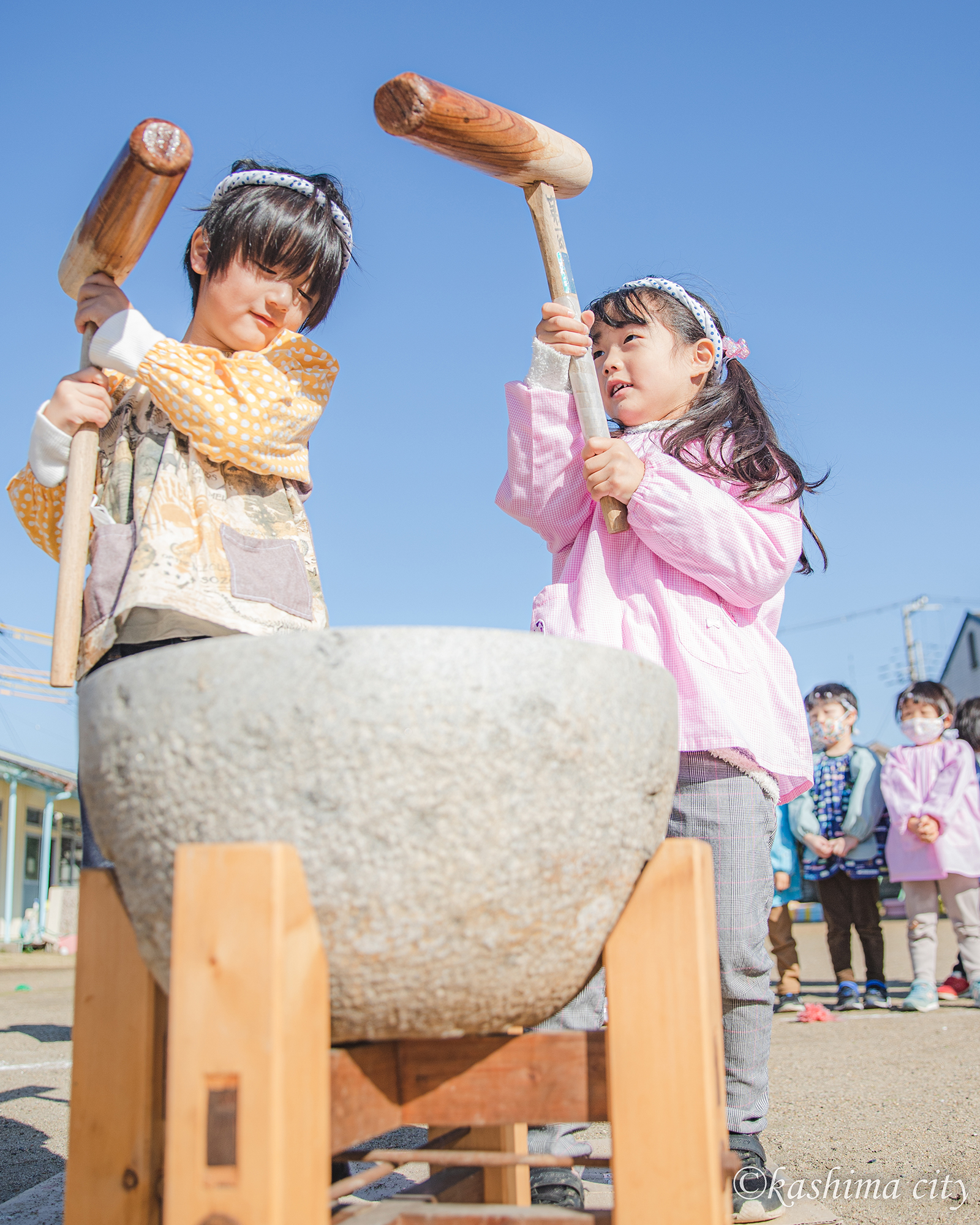 お餅つきをする男の子と女の子