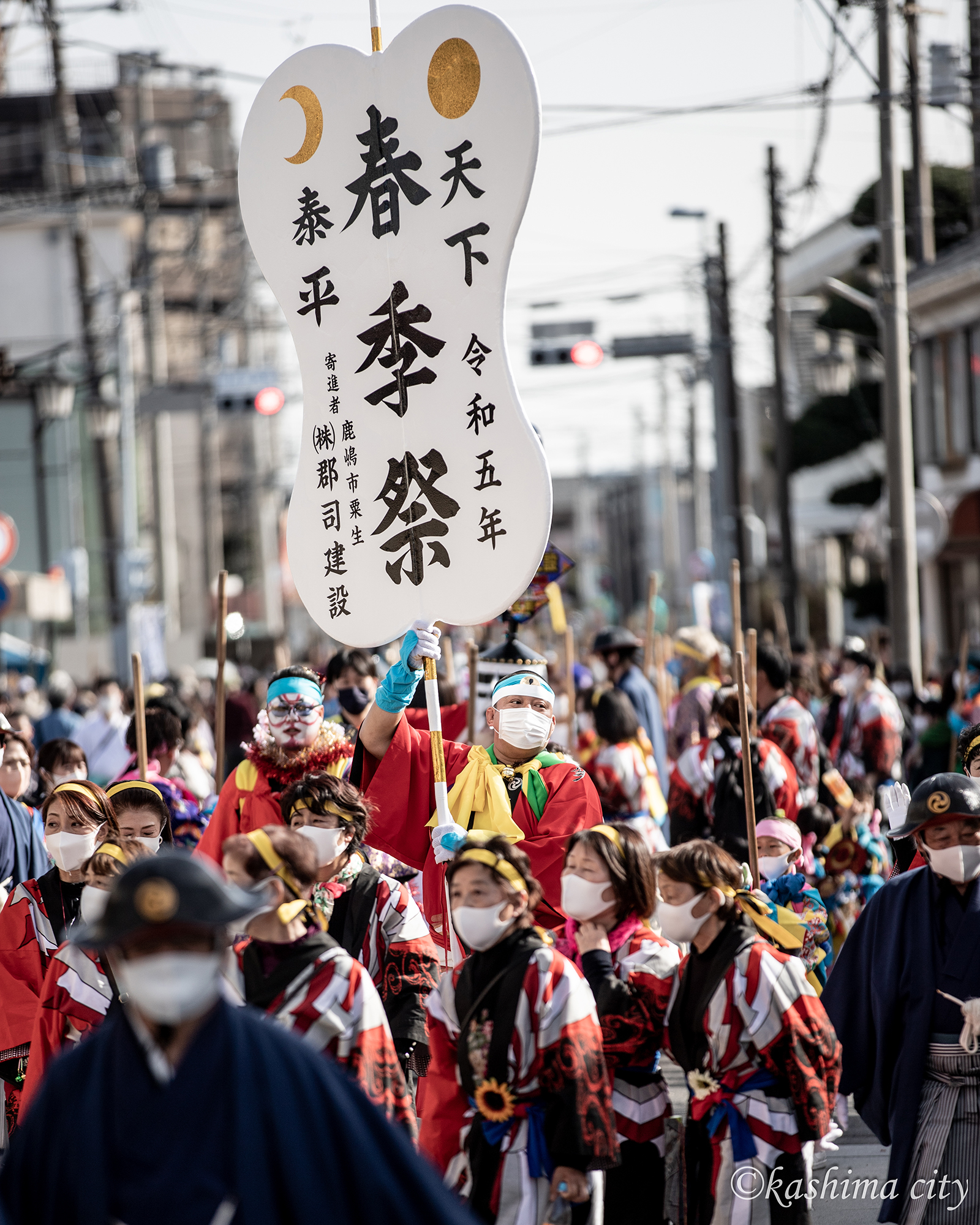 春季祭のうちわをもつ男