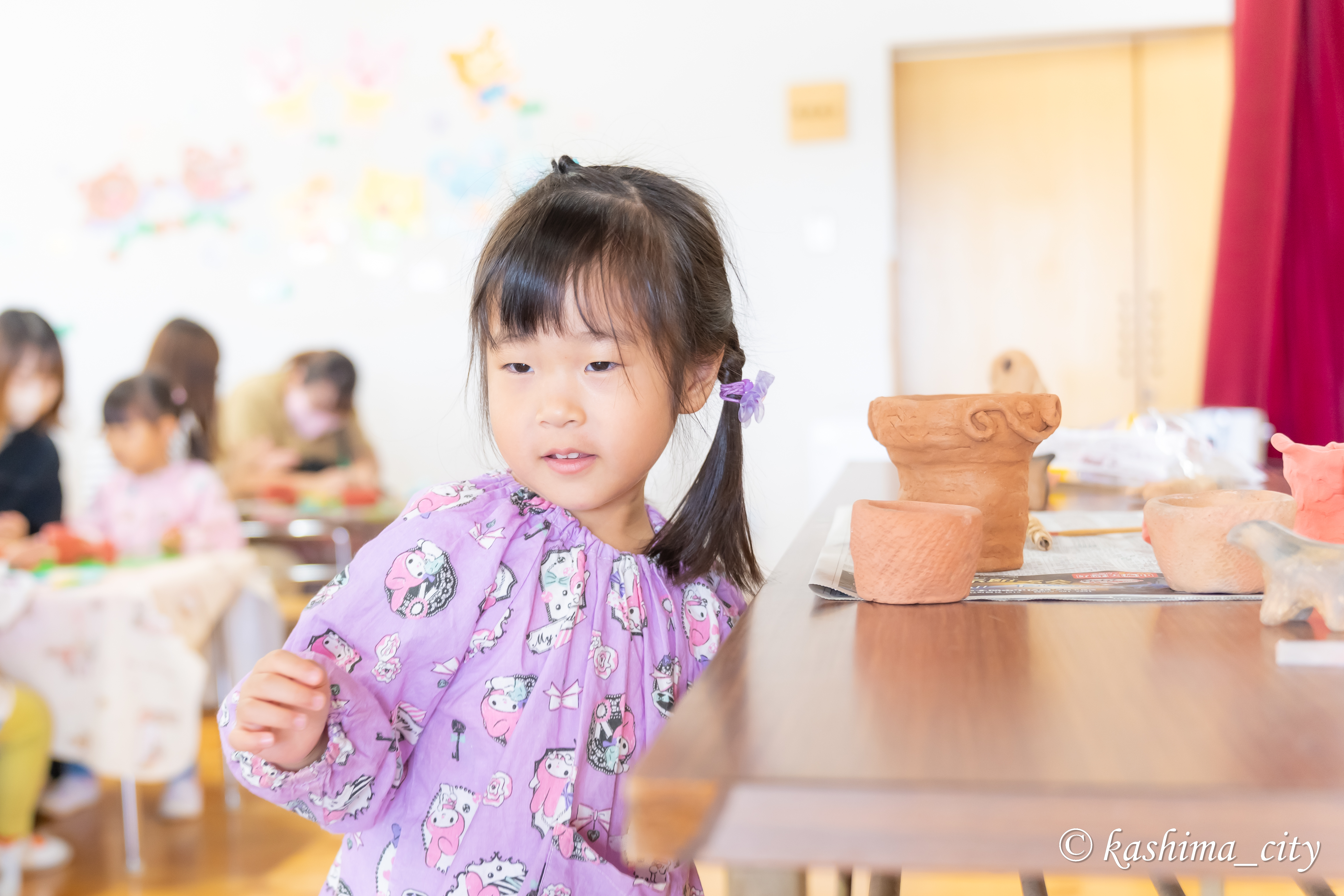 土器の横に立つ女の子