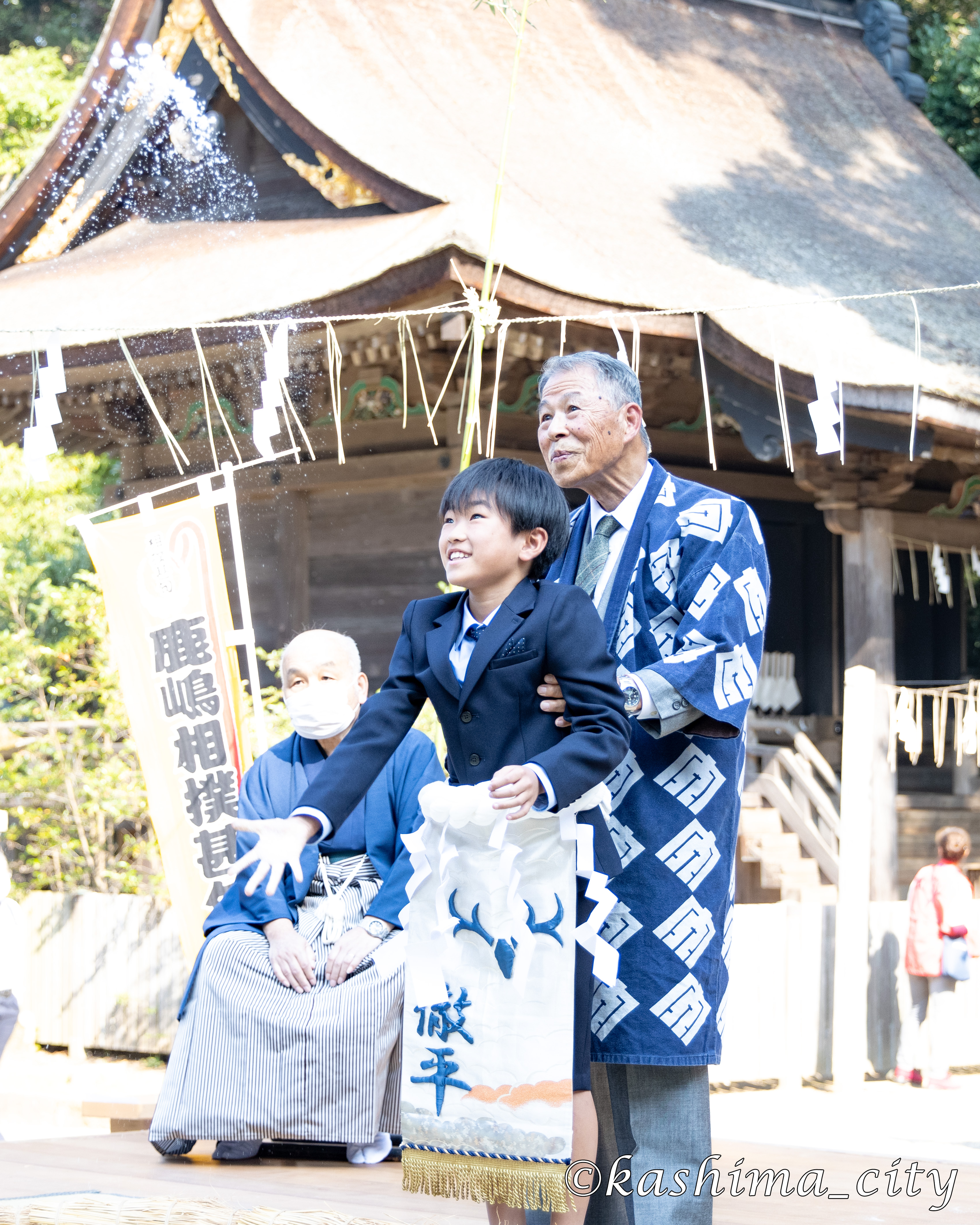 土俵入り前に塩をまく子ども