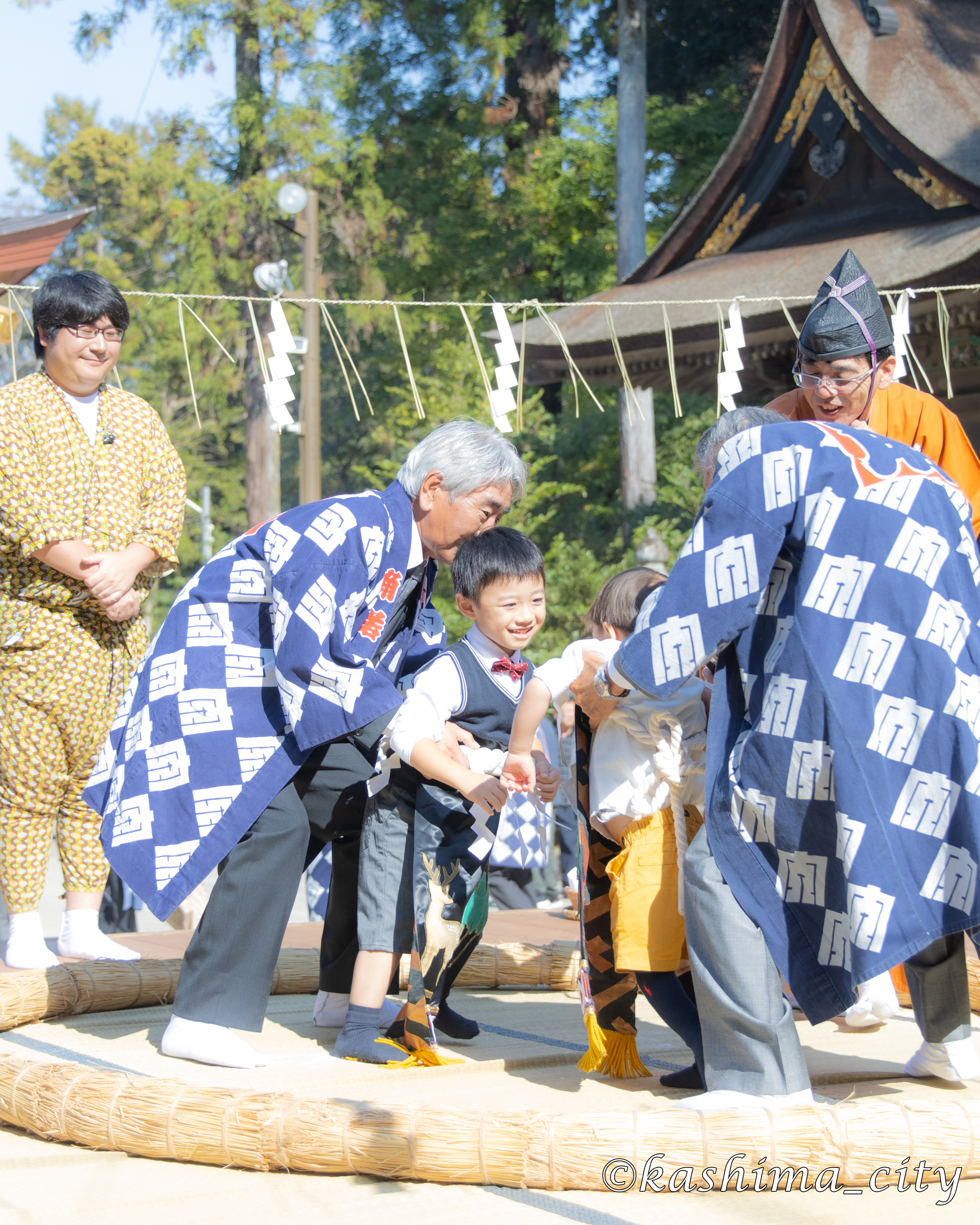 笑いながら相撲をとる子ども