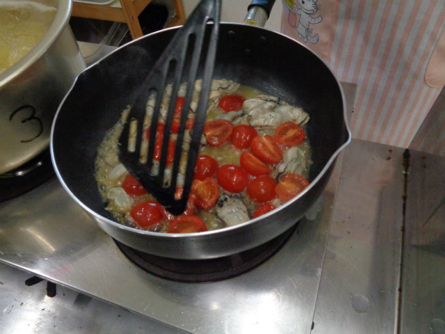 パスタソーストマトと牡蛎を炒めてる様子