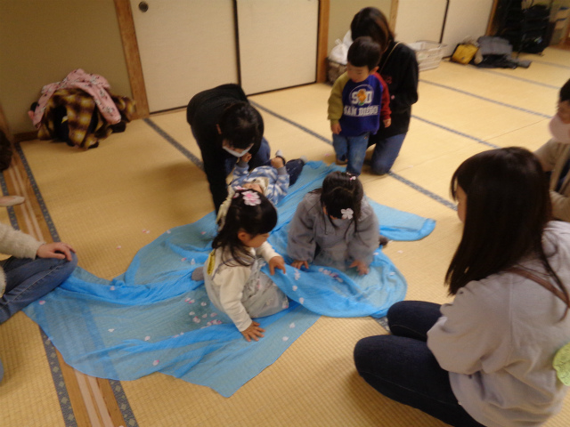 桜の花びらで遊ぶ子どもたち