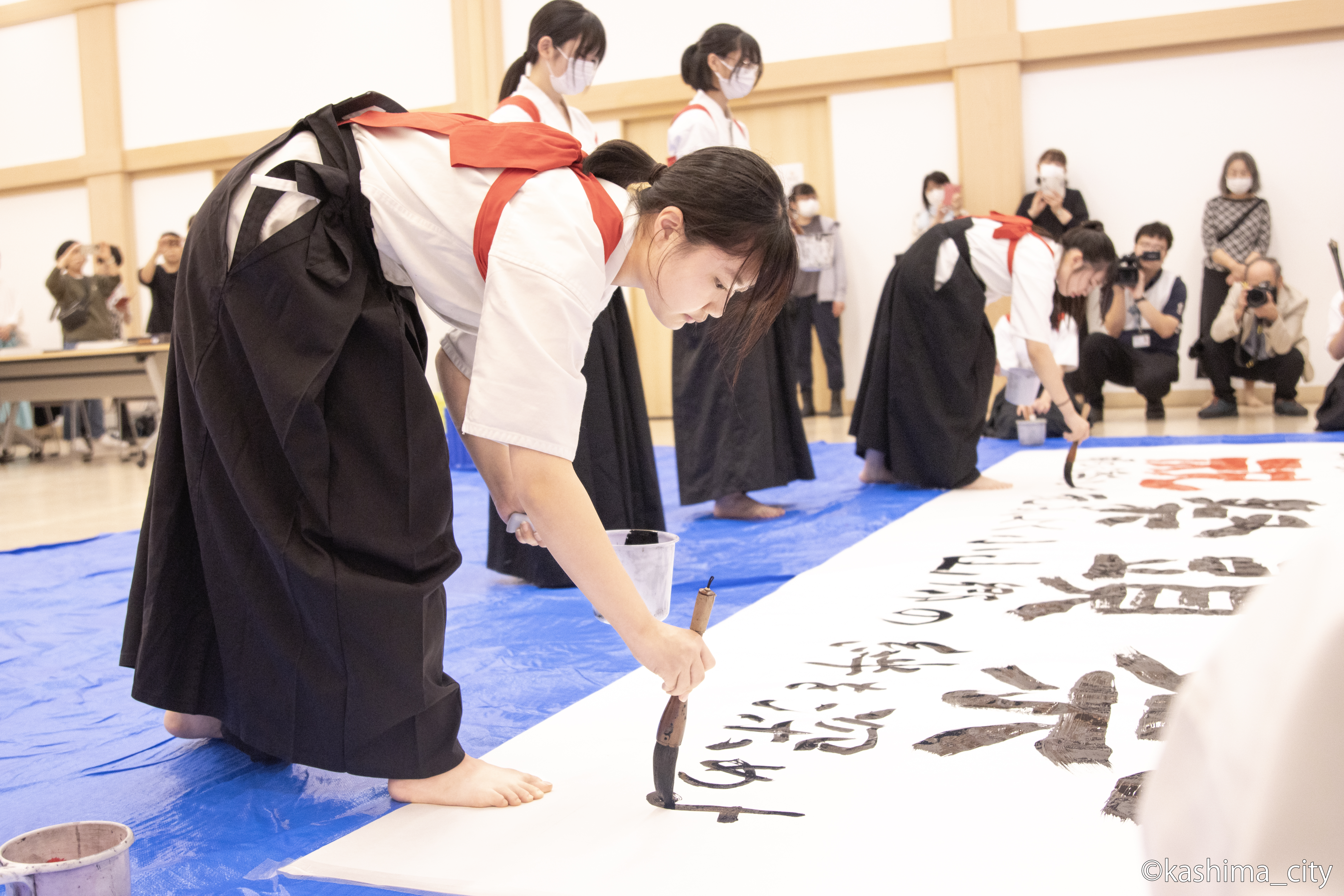 少し小さい筆でスローガンを書き入れる様子