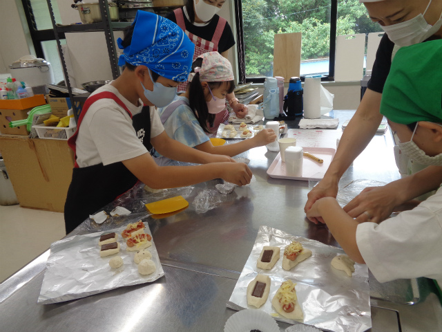 親に手伝ってもらいパンを作る子どもたち