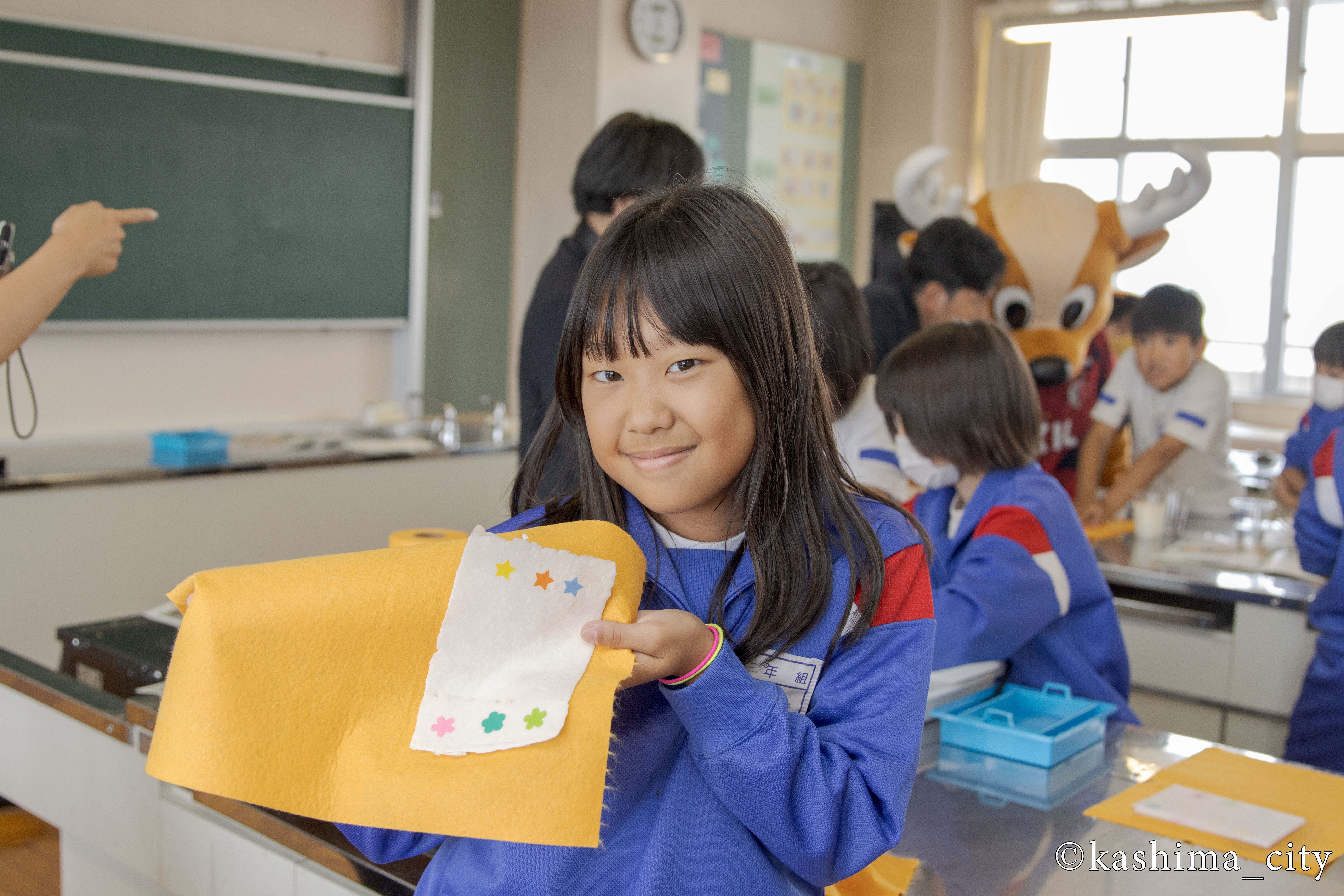 完成したメッセージカードを見せてくれる女子児童