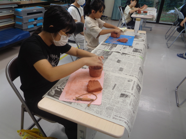 作った土器の隙間を埋める子ども