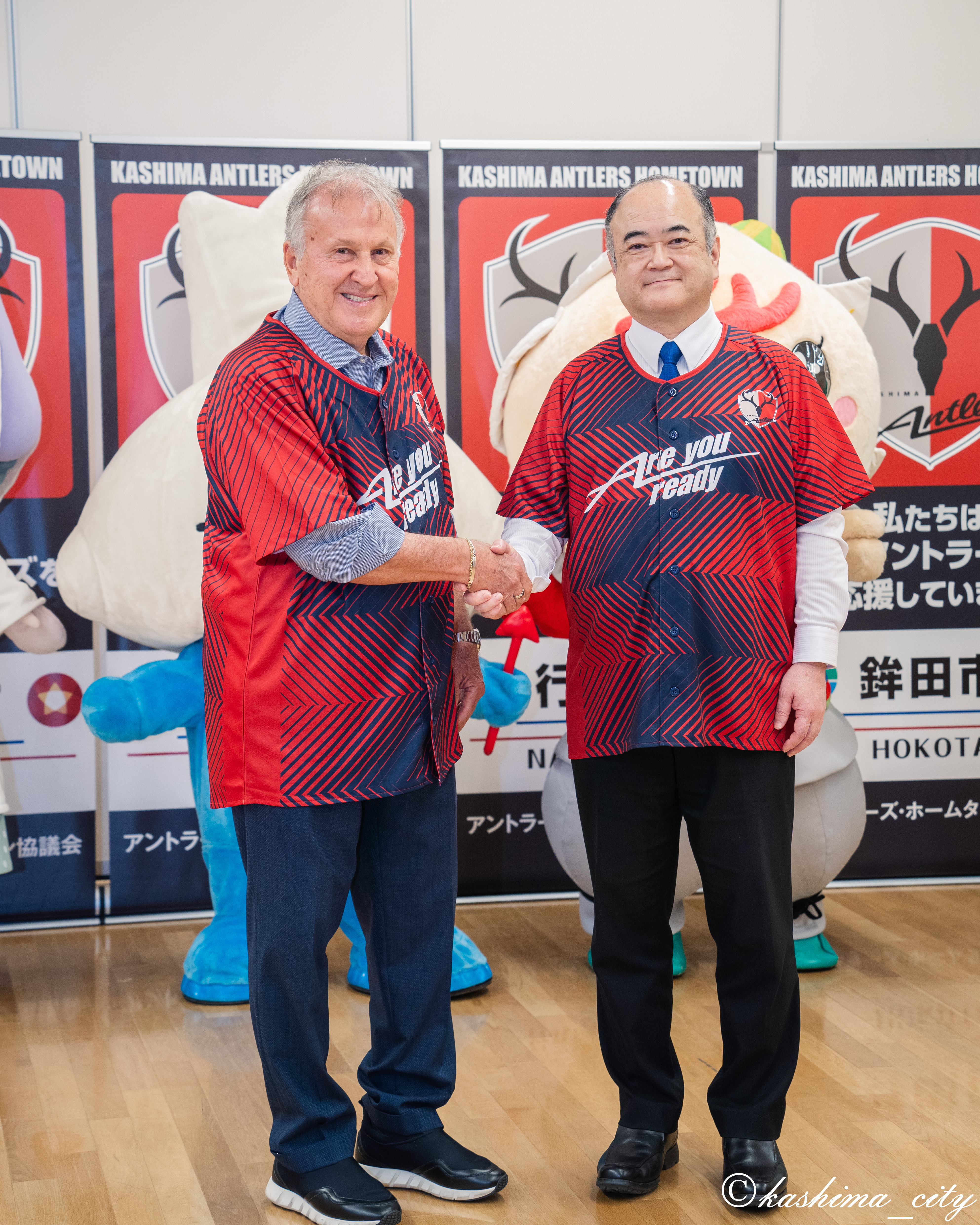 シャツを着て握手するジーコ氏と田口市長