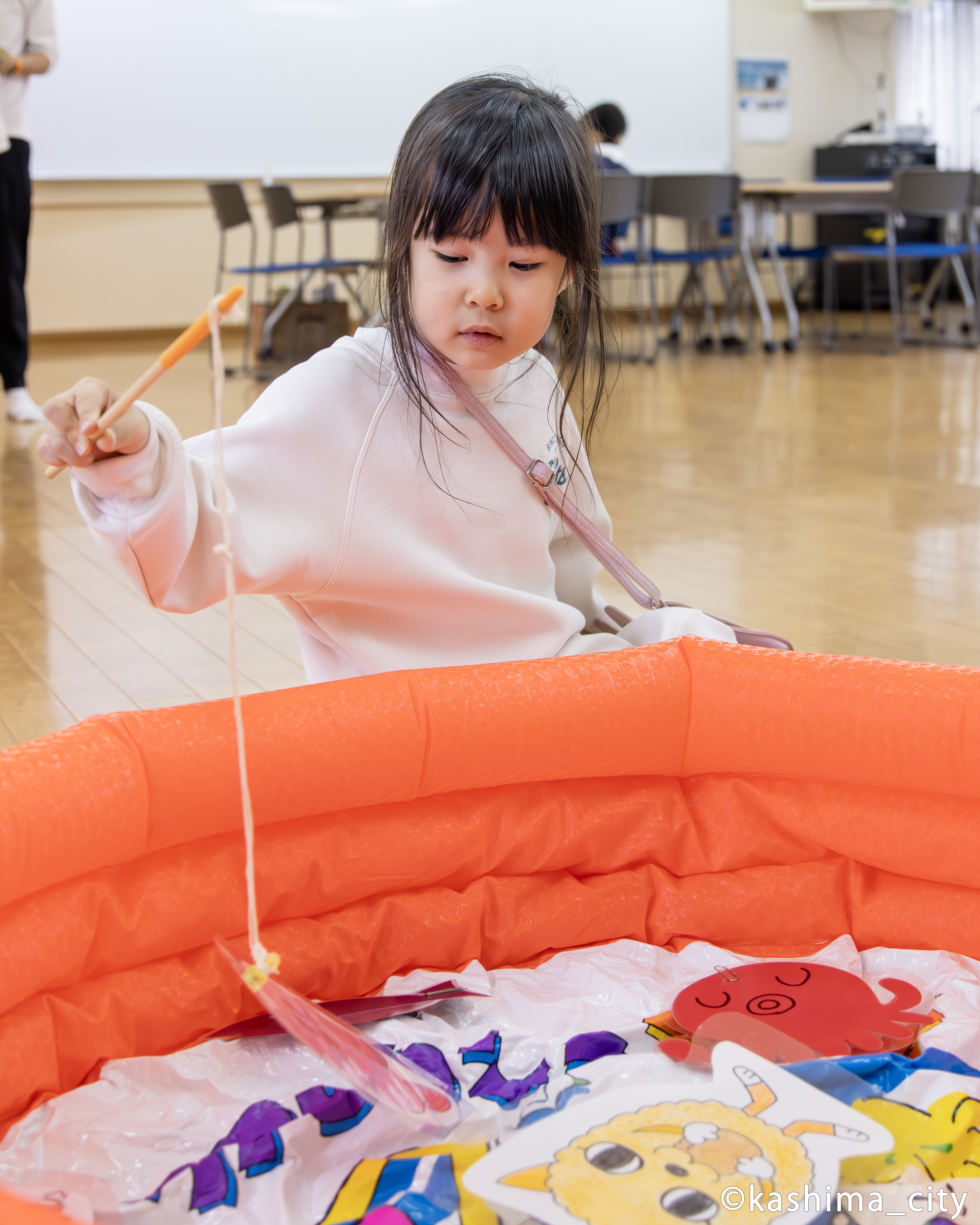 マグネット釣り竿で遊ぶ小さな女の子