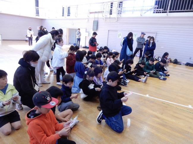 ビンゴ大会でカードの数字を探す子ども達