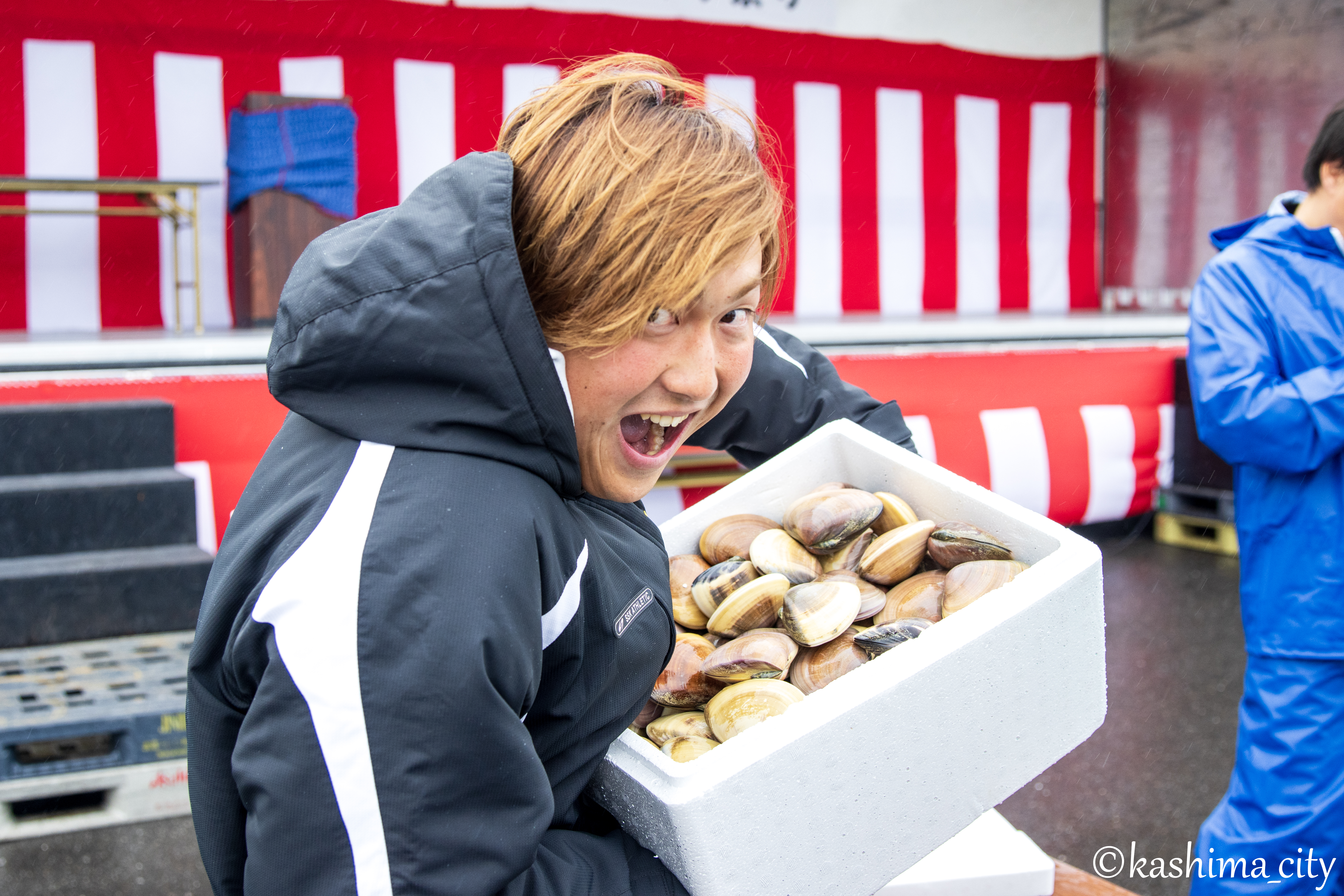 模擬競りではまぐりを競り落として喜ぶ男性