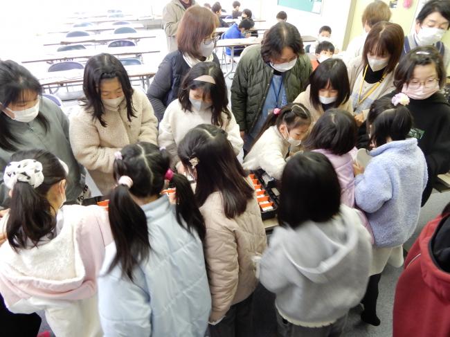 文字が書いてあるタイルを選んでいる子ども達。