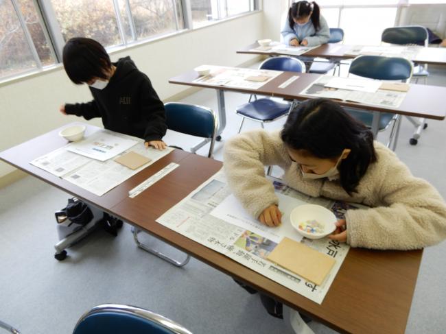 紙の上にタイルを置いてデザインを考えている様子。