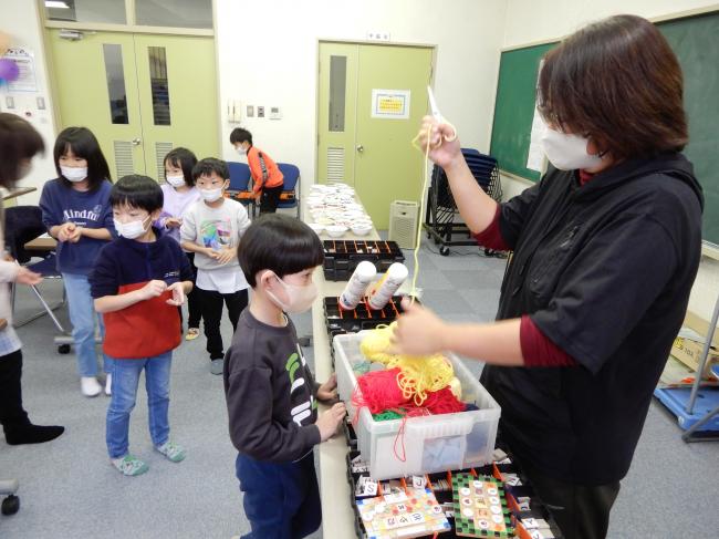 プレートを掛ける糸を選んでいる様子。