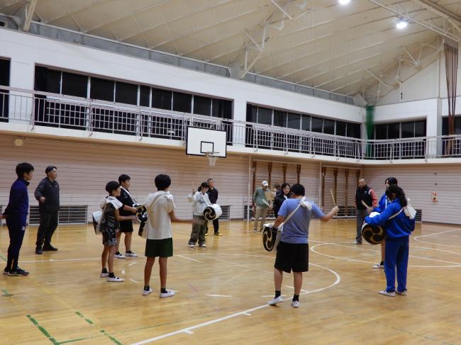 円になって太鼓の練習をしている写真