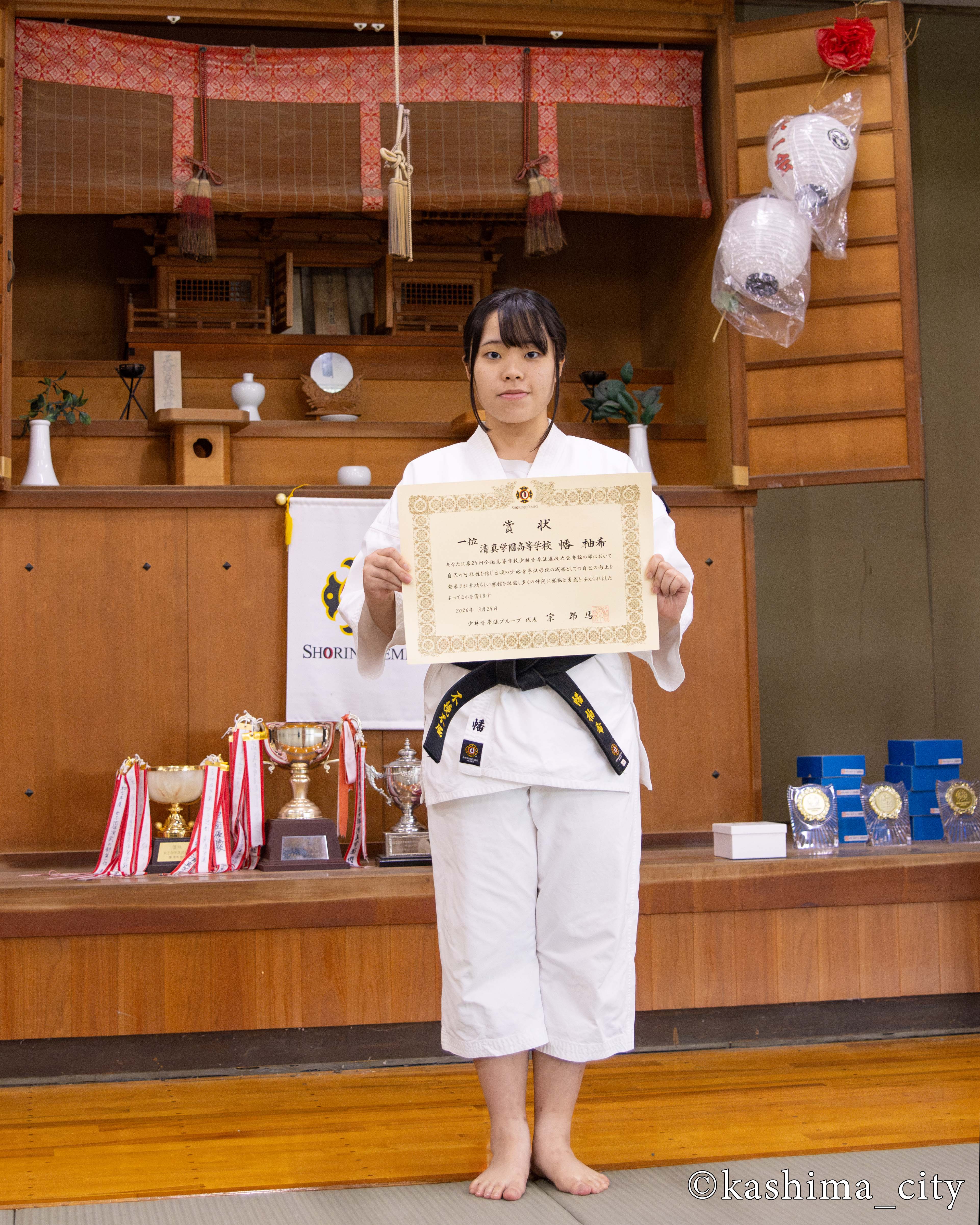 賞状をもって写真を撮る幡さん