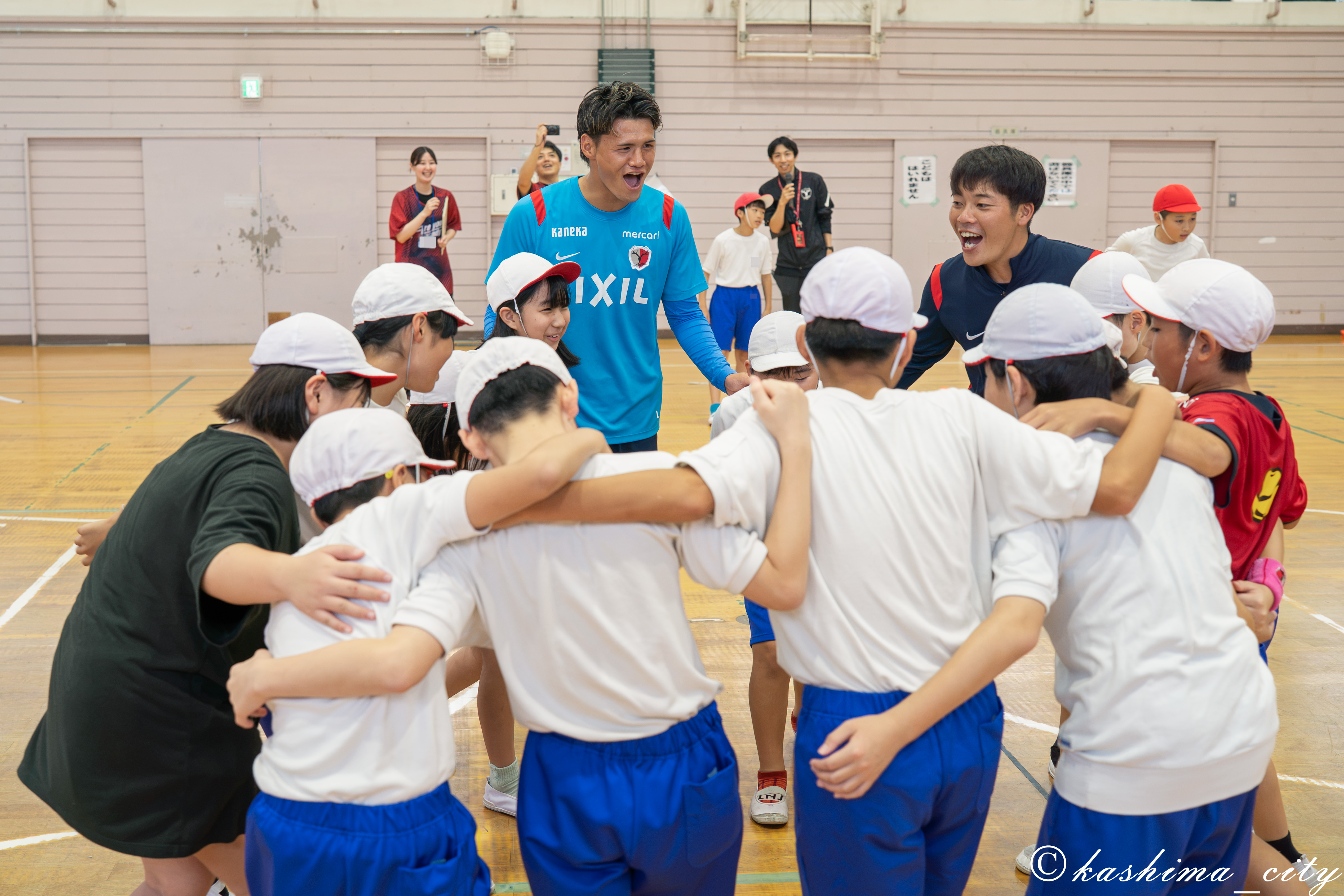児童と円陣を組む関川選手