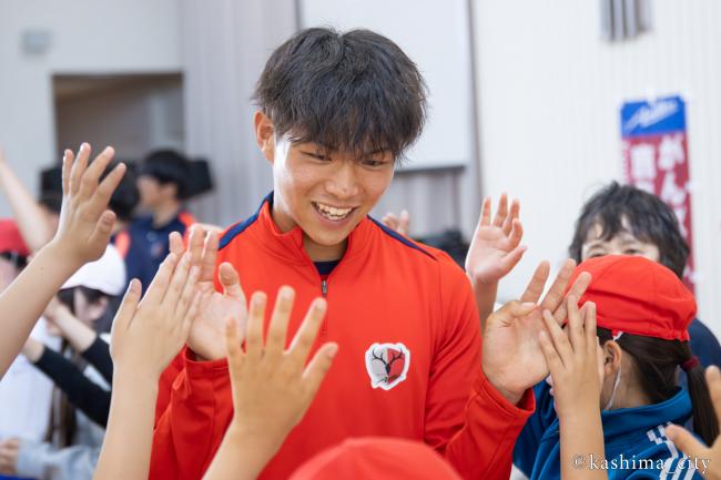 小学生に歓迎される佐藤選手