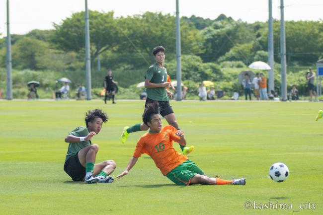 八千代高校の選手がスライディングでゴールに押し込む